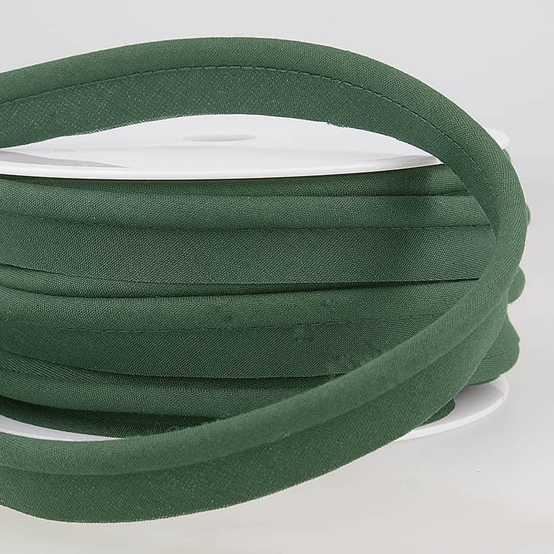 spool of dark green coloured piping on a white surface.