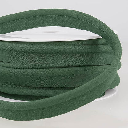spool of dark green coloured piping on a white surface.