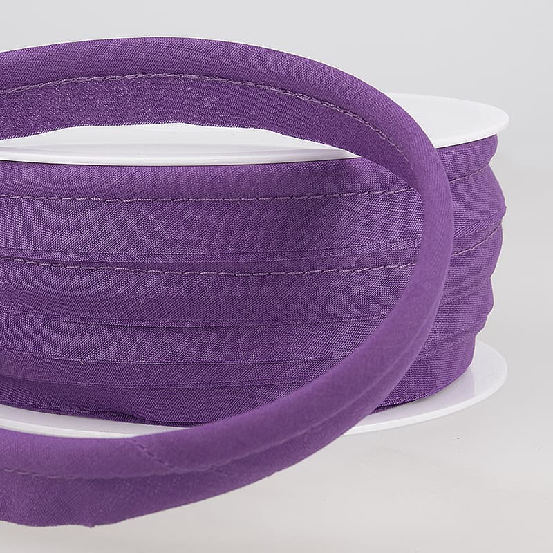 Purple piping on a white spool against a light gray background