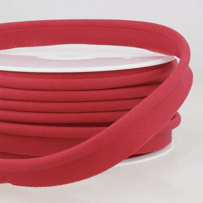 Spool of red piping on a white surface.